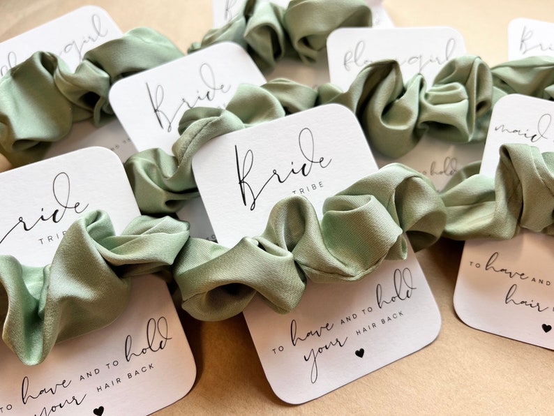 Peut inclure: Ensemble de chouchous en satin vert avec des cartes blanches qui disent "Bride Tribe" et "To have and to hold your hair back".