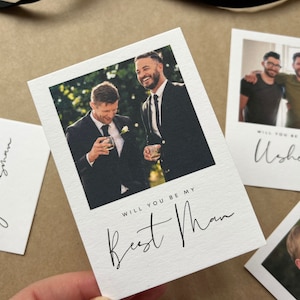 May include: A collection of white cards with photographs and handwritten text, designed for wedding proposals. The cards feature images of men and the phrases "Will you be my Best Man", "Groomsman", and "Usher".