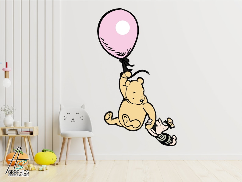 Puede incluir: Una calcoman&iacute;a de pared de Winnie de Pooh y Piglet que muestra a Winnie de Pooh sosteniendo un globo rosa y Piglet agarr&aacute;ndose del brazo de Winnie de Pooh. La calcoman&iacute;a est&aacute; en una pared blanca.
