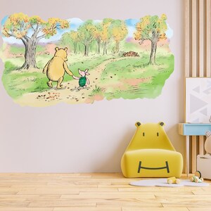 May include: Winnie the Pooh and Piglet walk along a path in a forest with autumn foliage. The illustration is in a watercolour style and is printed on a white background.