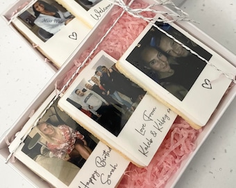 May include: A white gift box filled with pink tissue paper and four decorated cookies. Each cookie features a photograph and a personalized message. The messages include "Happy Birthday Sarah", "Love From Kaleb & Kelsey", "Miss Wales", and "Welcome".