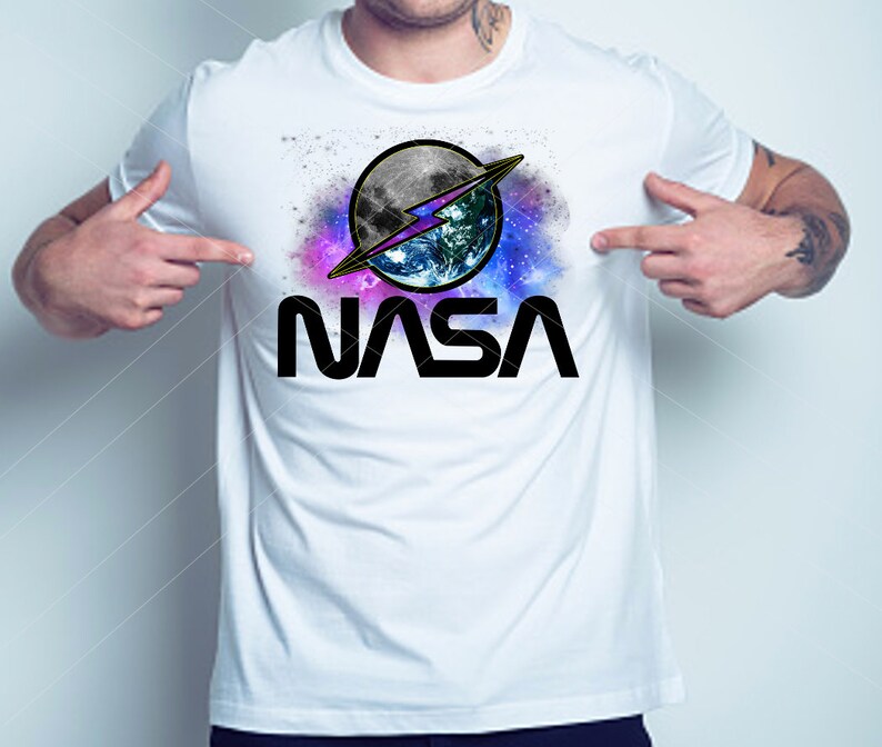 May include: White t-shirt with a graphic of a stylised NASA logo featuring a blue and green Earth with a lightning bolt and a moon in a galaxy background. The text "NASA" is printed in black below the graphic.