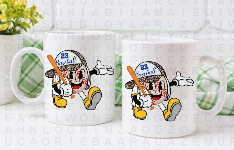 Peut inclure: Deux tasses en c&eacute;ramique blanche avec un motif sur le th&egrave;me du baseball. Le motif repr&eacute;sente un ballon de baseball de dessin anim&eacute; avec un visage, portant un chapeau qui dit "23 Baseball".
