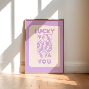 A purple playing card with the phrase Lucky You on top.