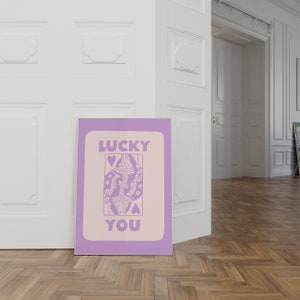 A purple playing card with the phrase Lucky You on top.