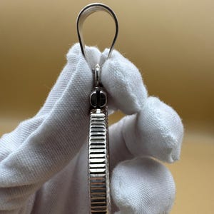 Puede incluir: Pendiente de plata con un dise&ntilde;o redondo texturizado y un bucle en la parte superior para sujetar una cadena.