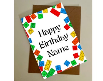 May include: A white card with a colorful Lego brick pattern border. The card says "Happy Birthday Name".
