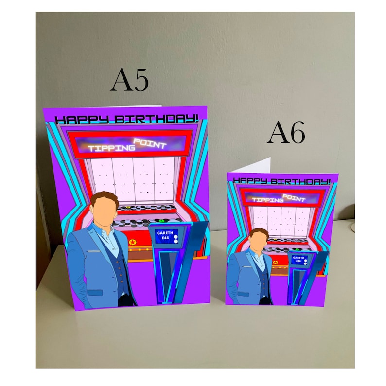 May include: Two birthday cards featuring a cartoon illustration of a person standing in front of a game show set. The game show is called "Tipping Point" and the text "Happy Birthday!" is on both cards. The larger card is A5 size and the smaller card is A6 size.
