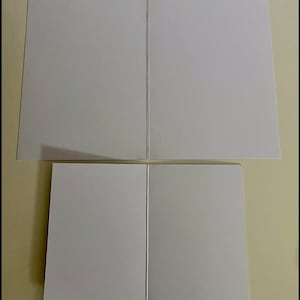 May include: Two blank white greeting cards folded in half. The cards are stacked on top of each other. The text "Blank Inside" is printed below the cards.