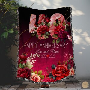 Könnte beinhalten: Eine rote und schwarze Wolldecke mit einem Blumendesign und der Zahl 40 in der Mitte. Der Text "Happy Anniversary Sam and Maria 1985 2025" ist auf der Decke aufgedruckt.