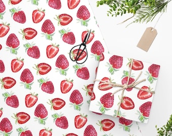 Puede incluir: Papel de regalo blanco con un patrón repetido de fresas rojas. Las fresas están dibujadas en estilo acuarela y están dispersas por el papel.