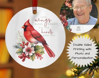 May include: A double-sided, round Christmas ornament with a red ribbon. One side features a red cardinal bird illustration with text. The other side has a photo of a person. The ornament has the text "YOUR wings WERE READY BUT OUR hearts WERE NOT."
