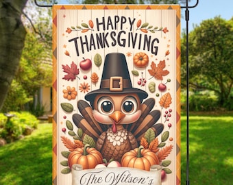 May include: Thanksgiving garden flag featuring a cartoon turkey wearing a pilgrim hat, surrounded by pumpkins, leaves, and the text "Happy Thanksgiving." A banner at the bottom reads "The Wilson's."