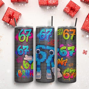 May include: Three stainless steel tumblers with black straws, each with a graffiti-style design. The number "67" is displayed in bright colours on each, set against a grey brick wall. Red gift boxes with bows and snowflakes surround the tumblers.
