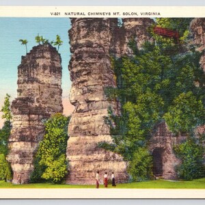 May include: A vintage postcard featuring a scenic view of the Natural Chimneys in Mt. Solon, Virginia. The postcard shows two tall, narrow rock formations with a small bridge in the background. The text "V-821 NATURAL CHIMNEYS MT. SOLON, VIRGINIA" is printed at the top of the postcard.