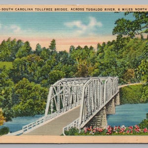 May include: Vintage postcard featuring the Georgia-South Carolina Tollfree Bridge over the Tugaloo River. The bridge is white, with a metal truss design, and spans a blue river. Lush green trees and a blue sky complete the scenic view.