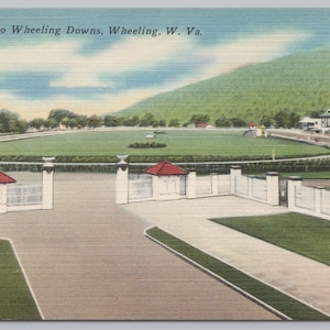 May include: A vintage postcard showing the entrance to Wheeling Downs in Wheeling, West Virginia. The image features a white gated entry with red-roofed pillars, a large green racetrack, and a grandstand building under a blue sky with clouds.