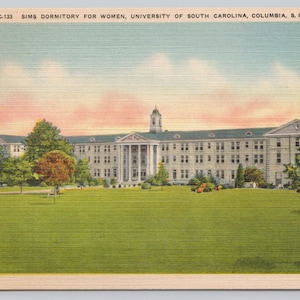 May include: Vintage postcard featuring Sims Dormitory for Women at the University of South Carolina. The building is a large, multi-story structure with a white facade, columns, and a central tower. A green lawn and trees are in the foreground.