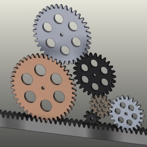 May include: A set of five interlocking gears, with a grey, black, orange, and white colour scheme. The gears are arranged in a staggered pattern, with the largest gear at the top and the smallest gear at the bottom.