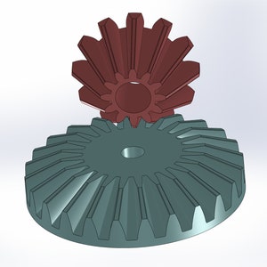 Può includere: Due ingranaggi metallici, uno è un ingranaggio più grande di colore verde acqua con un ingranaggio più piccolo di colore marrone rossiccio sopra.