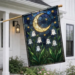 May include: A rectangular garden flag featuring a stained glass style design of a crescent moon and yellow stars against a dark blue night sky. Below the moon, several small white ghost figures are nestled among green leafy plants.