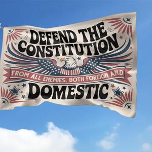 May include: A flag waving in the wind against a blue sky. The flag features the text "DEFEND THE CONSTITUTION" above an eagle graphic with the text "FROM ALL ENEMIES, BOTH FOREIGN AND DOMESTIC". The flag has red, white, and blue accents.