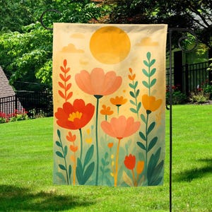 May include: A decorative garden flag featuring a floral design with large orange and red flowers, green leaves, and a yellow sun against a cream background. The flag is displayed on a black metal stand in a grassy yard.