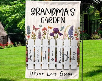 May include: A white garden flag with a picket fence design and colorful flowers. The text "Grandma's Garden" is at the top of the flag, and the text "Where Love Grows" is at the bottom. The names of seven people are written on the fence pickets: Jessica, Luciana, David, Ariana, Bennigan, Sophia, and Percy.