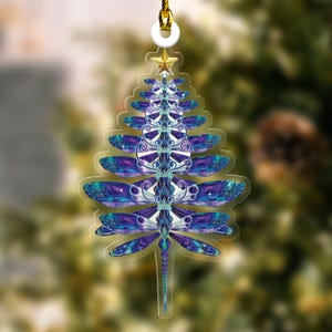 May include: A Christmas tree ornament shaped like a dragonfly with blue, purple, and green wings. The ornament is made of clear acrylic and has a gold string for hanging.