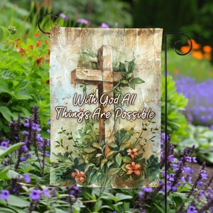 May include: A garden flag with a rustic wooden cross and floral design. The text "With God All Things Are Possible" is printed on the flag.
