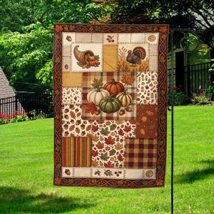 May include: A rectangular garden flag featuring a patchwork design with autumn themes. The print includes illustrations of pumpkins, a cornucopia, a turkey, acorns, and fall leaves in shades of orange, brown, yellow, and green with a dark border.