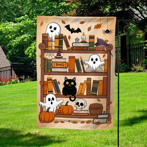 May include: A Halloween-themed garden flag featuring a bookshelf design with ghosts, pumpkins, a black cat, and a skull. The bookshelf is filled with books, candles, and a witch's hat. The flag is decorated with falling leaves and a spider.