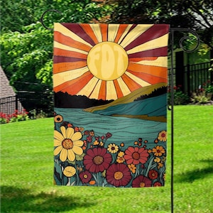 May include: A garden flag featuring a retro-style illustration of a sunburst over a landscape with a river and flowers. The sun is yellow, and the rays are orange and red. The flowers are yellow and burgundy.