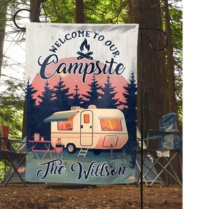 May include: A welcome to our campsite garden flag with a vintage camper, a campfire, and trees in the background. The text on the flag reads "Welcome to our Campsite The Wilson".