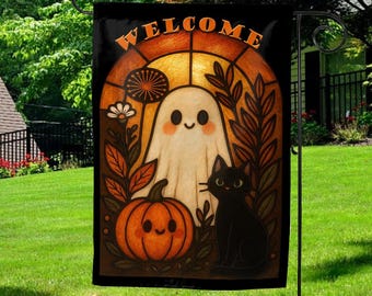 May include: A Halloween garden flag featuring a friendly ghost, a black cat, and a smiling pumpkin. The word "WELCOME" is arched across the top in orange. The design is set against a stained-glass style background with autumn leaves and flowers.
