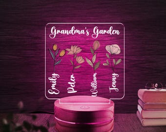 May include: A wooden base with a clear acrylic panel displaying the text "Grandma's Garden" with four stylized floral designs and names "Emily, Peter, William, Jenny" underneath each design.