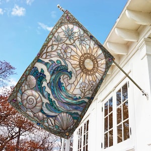 May include: A rectangular garden flag featuring a stained glass style design of a large ocean wave, a radiant sun, and various seashells. The artwork includes shades of blue, teal, and cream, with a decorative border and small purple accents.
