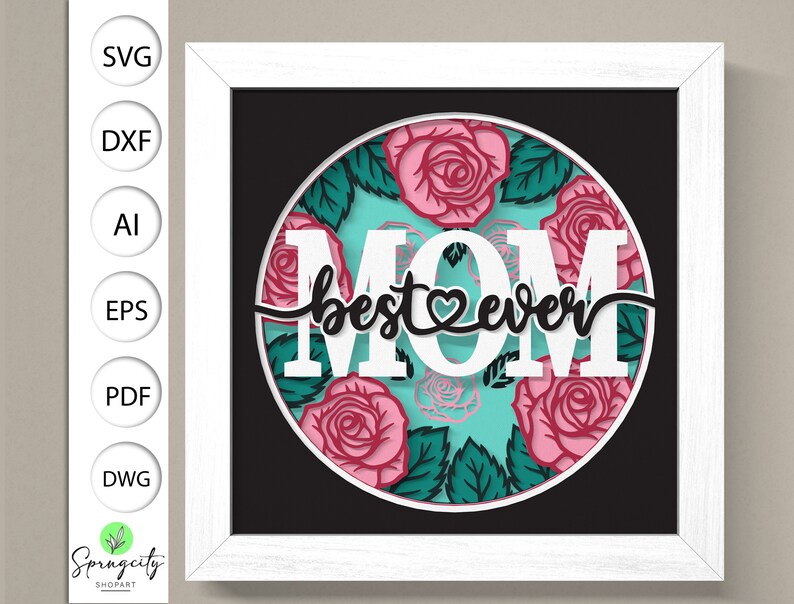 May include: White paper cut-out design with the words "MOM best ever" in a circle surrounded by pink and green roses.