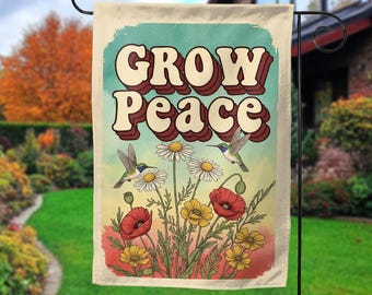 May include: A garden flag with the words "GROW Peace" in a retro font. The flag features illustrations of hummingbirds, daisies, poppies, and other wildflowers in a vintage style, with a teal and cream background.