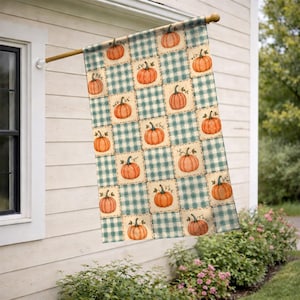 May include: A rectangular decorative flag featuring a repeating grid pattern of teal and white buffalo check squares. Each square contains a watercolor-style illustration of a single orange pumpkin with a brown stem, arranged in a staggered layout.
