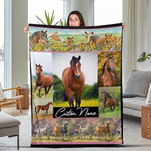 May include: A rectangular horse-themed blanket featuring various images of horses in different poses and settings. The blanket has a pink border and includes the text "Custom Name" in a cursive font. The blanket is held up by a person.