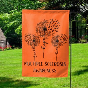 May include: Orange garden flag with three black dandelion designs. Each dandelion is made up of orange awareness ribbons. The text "faith", "hope", and "love" are written on the stems of the dandelions. The text "Multiple Sclerosis Awareness" is printed at the bottom of the flag.