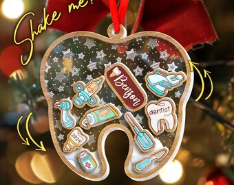 May include: A tooth-shaped Christmas ornament with a wooden frame and clear center, filled with dental tools and stars. The ornament has the name "Benson" and the text "Shake me!" written on it. It is hanging from a red ribbon.