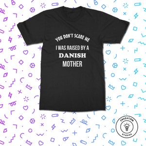 Może przedstawiać: Czarny t-shirt z białym napisem "YOU DON'T SCARE ME I WAS RAISED BY A DANISH MOTHER." Koszulka ma kr&oacute;tkie rękawy i okrągły dekolt. Koszulka pochodzi z Crazation Studios.