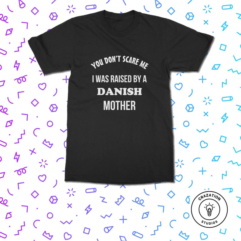 Może przedstawiać: Czarny t-shirt z białym napisem "YOU DON'T SCARE ME I WAS RAISED BY A DANISH MOTHER." Koszulka ma kr&oacute;tkie rękawy i okrągły dekolt. Koszulka pochodzi z Crazation Studios.