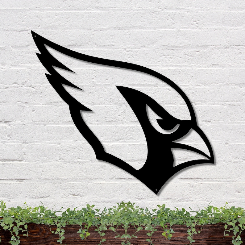 May include: Black metal silhouette of a cardinal bird head with a wing on a white brick wall. The cardinal is facing the right side of the image.