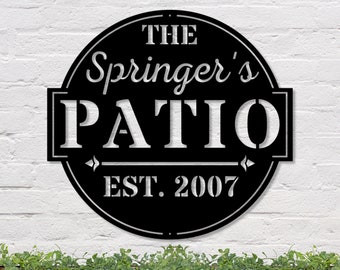 May include: Black metal sign with white text that reads "The Springer's Patio Est. 2007".