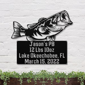 May include: Black metal silhouette of a largemouth bass with a sign below it that reads "Jason's PB 12 Lbs 10oz Lake Okeechobee, FL March 15, 2022".
