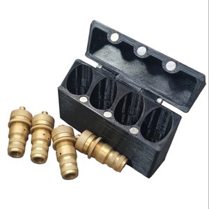 May include: A black plastic case with a hinged lid, containing four gold-colored metal connectors. The case has four compartments and is designed to hold the connectors securely.