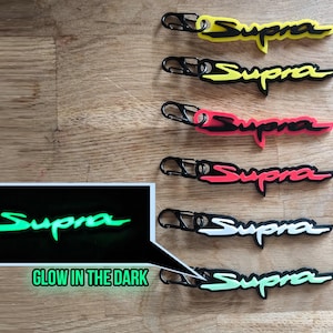 Può includere: Sei portachiavi con la parola "Supra" in diversi colori. Il portachiavi nella fila inferiore brilla al buio ed è verde.